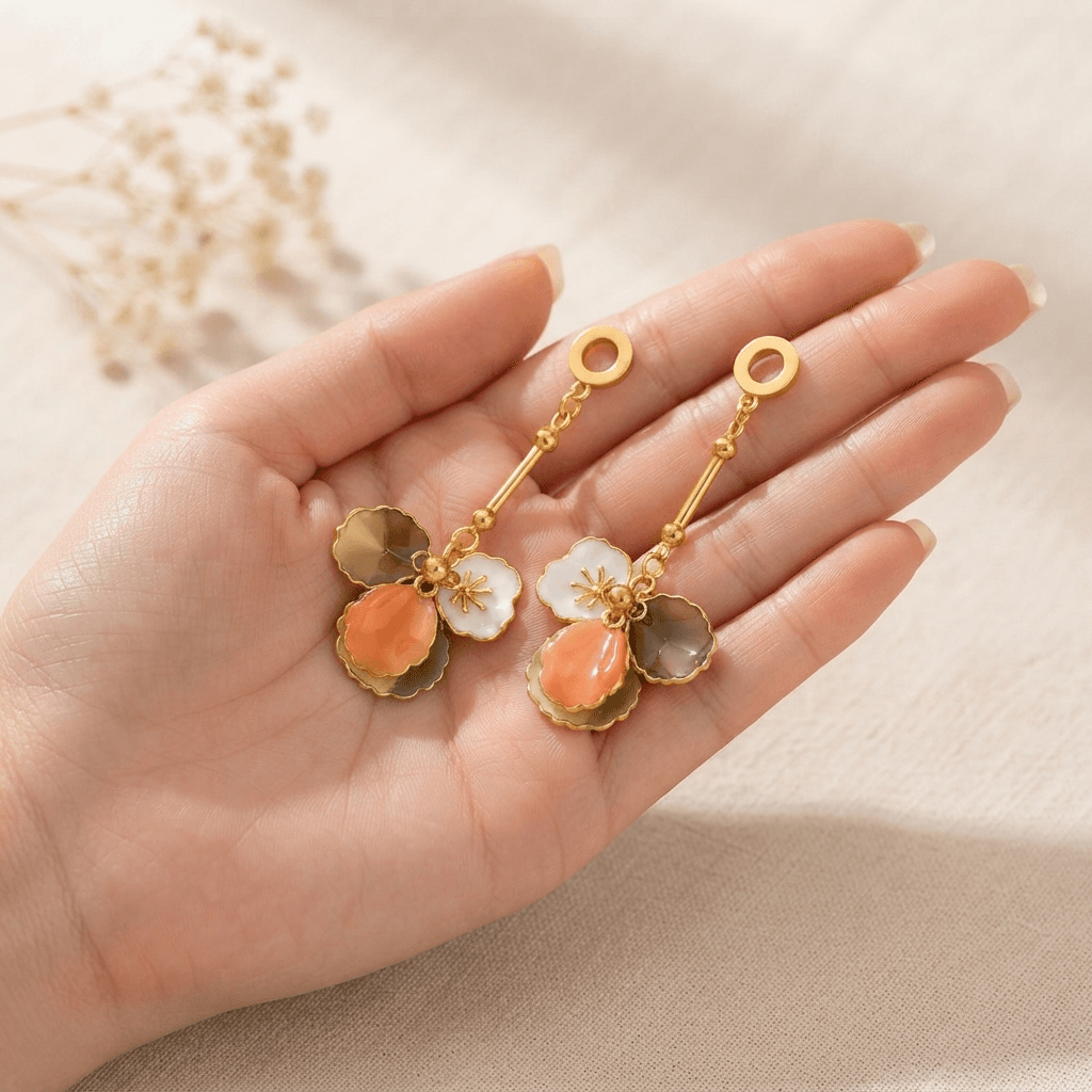 Peach Petal Drop Earrings, held in an open hand to show their size
